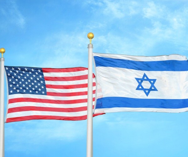 the u.s. and israeli flag fly next to each other