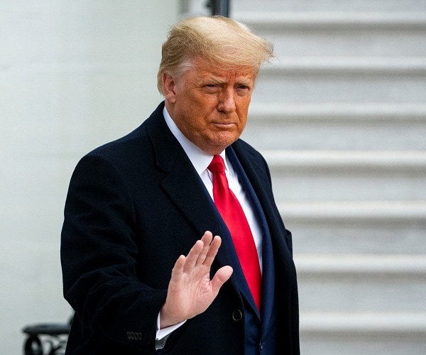 donald trump waves as he walks out of white house