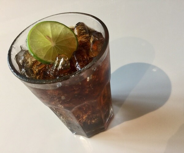 diet cola on ice in a glass with lime slice