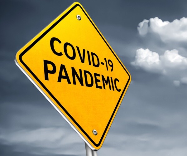 a yellow road sign says COVID Pandemic