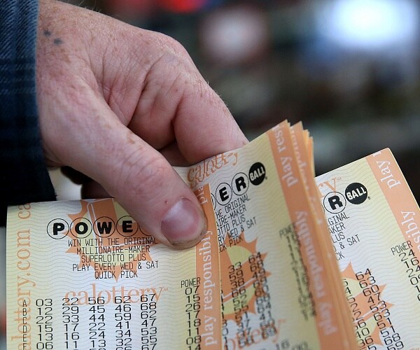 person holds handful of powerball tickets