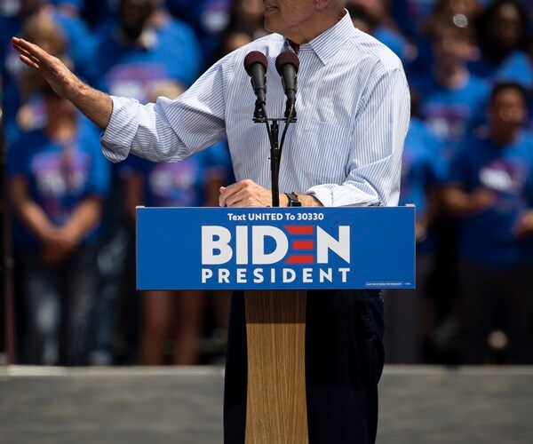 joe biden speaks hidden behind a podium