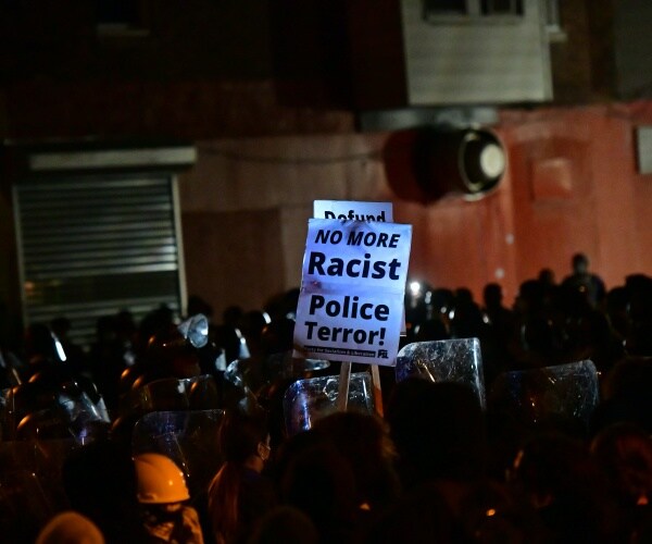 Police with shields form a line