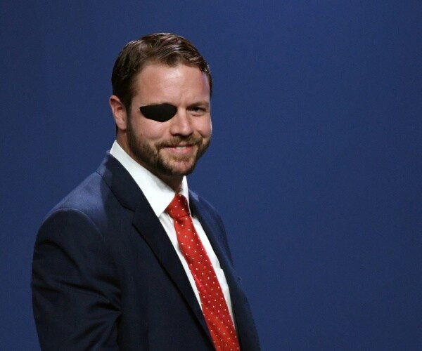 crenshaw in a suit and red polka dotted tie with blue background