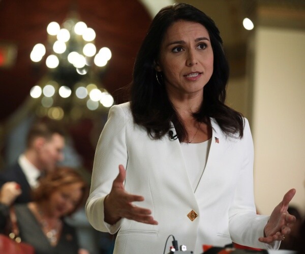 gabbard in a white top and blazer speaking at an event