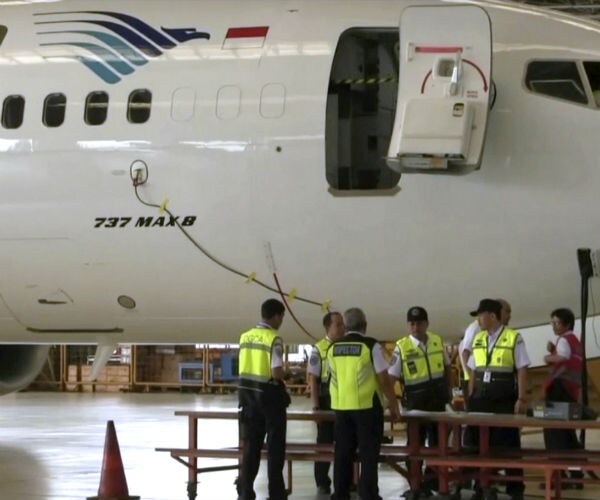 a crew in yellow vests stand in front of a boeing 737