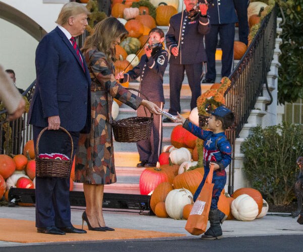 donald aand mellania trump giving candy to a child dressed as captain america