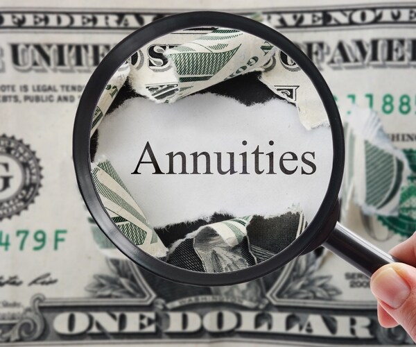 hand holding a magnifying glass over torn dollar bill with annuities text 