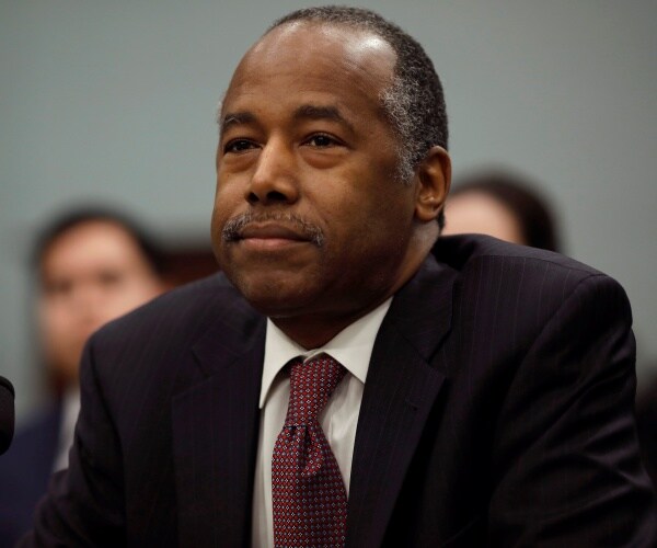 carson in a burgundy tie and black suit