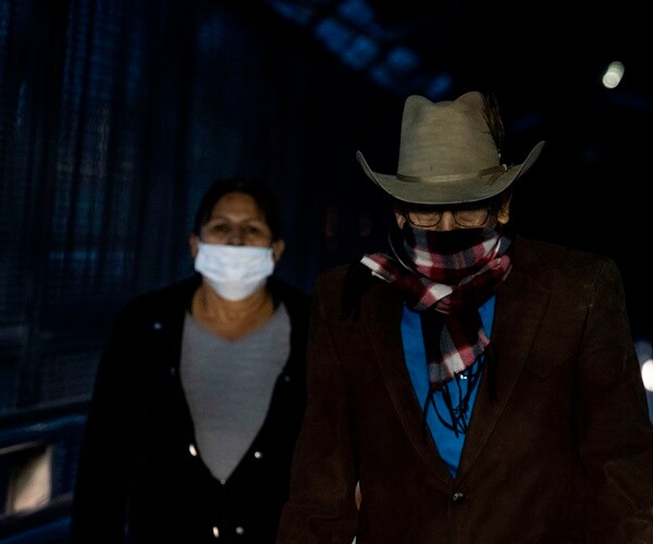 a man and a woman wear face protection crossing the u.s. border