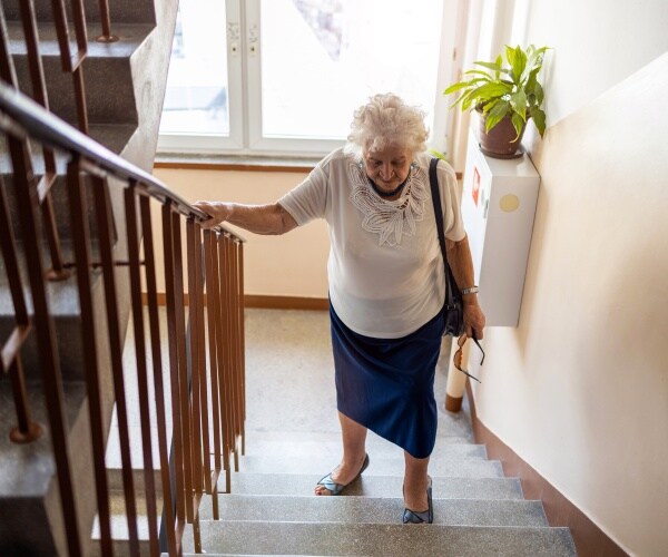 older woman having difficulty going upstairs