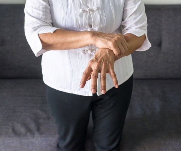 close up of older woman's hand having a tremor