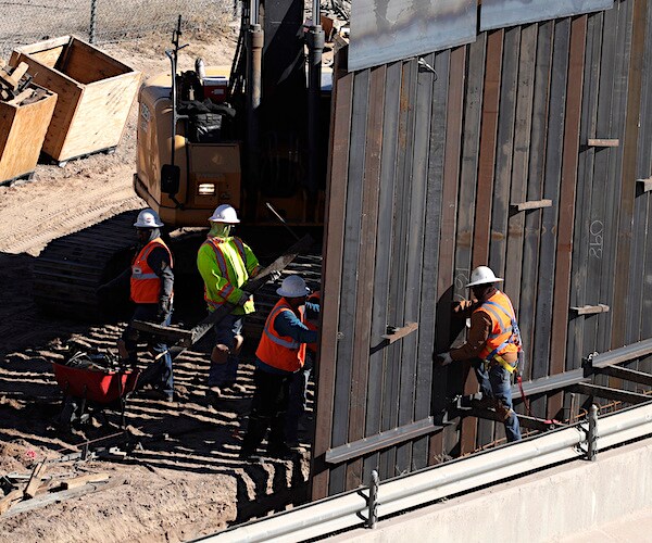 workers construct a section of border wall on the new mexico border with mexico