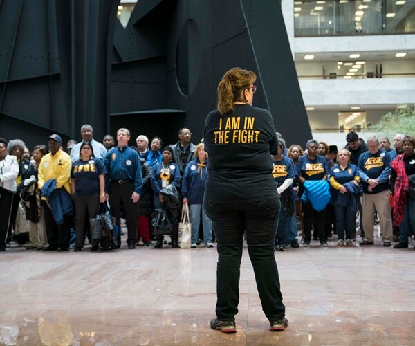 members of the afge stand in protest of the trump administration's policies to strip union members of benefits, rights.