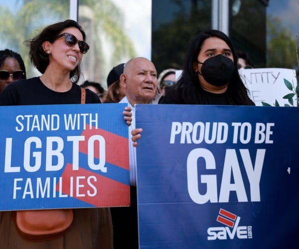 two women protest parental rights bill in florida with lbgtq signs