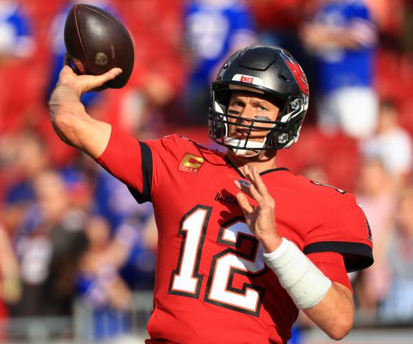 tom brady in uniform throwing a football