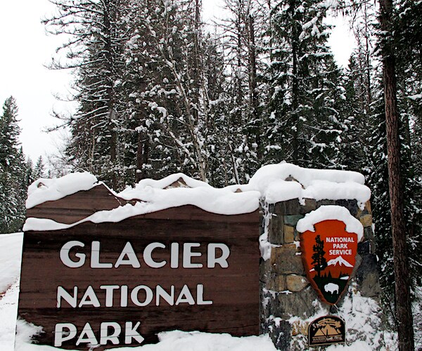 a snow covered Glacier National Park sign