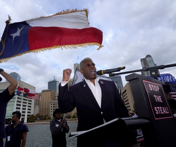 allen west stands under a texas flag, at a stop the steal podium and speaks.