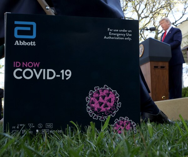 a coronavirus test kit from abbott laboratories is shown as president donald trump speaks at the white house