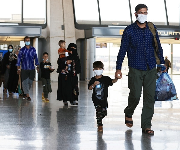 afghan refugees walk through airport