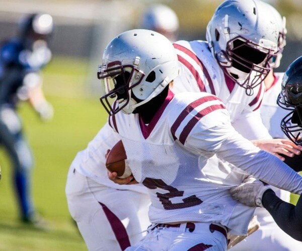 football players running a play during a game