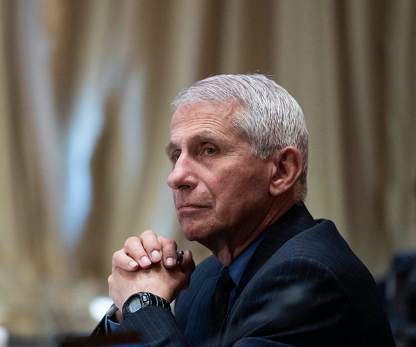 dr. anthony fauci folds his hands as he listens during a congressional hearing