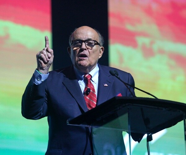 rudy giuliani speaks on a stage