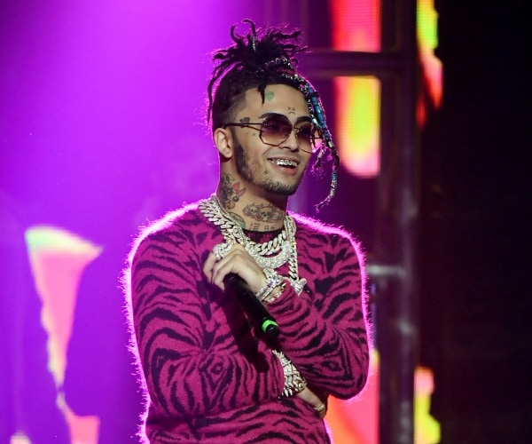 lil pump in purple and black zebra printed sweater and silver chains on stage