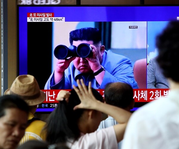 north korean leader kim jong un on tv with binoculars, supposedly watching a missile launch.