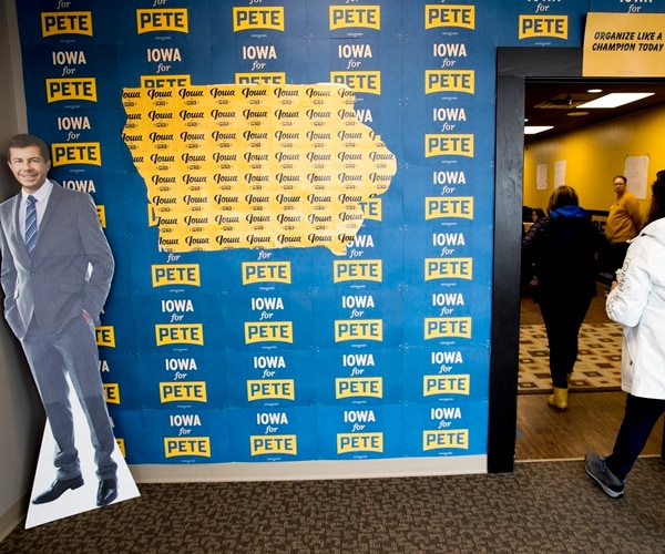 caucus voters walk in to vote past