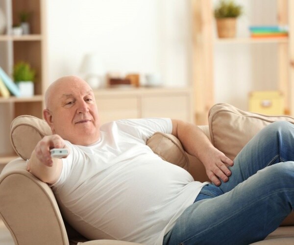 man on couch with tv remote