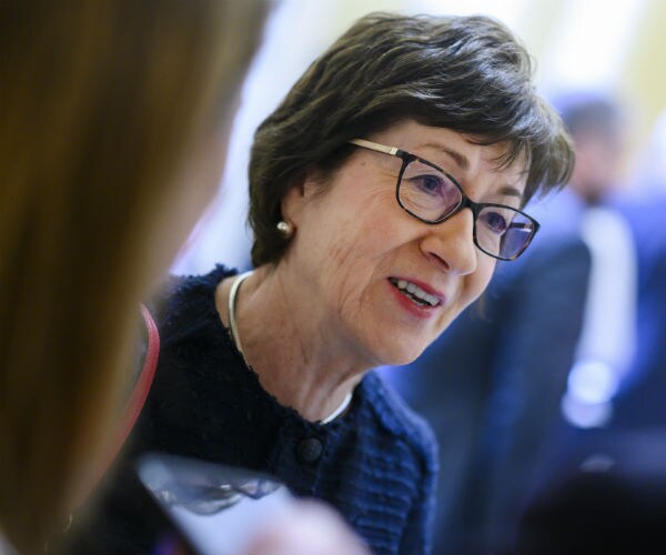 sen. susan collins is shown wearing glasses in navy blue attire