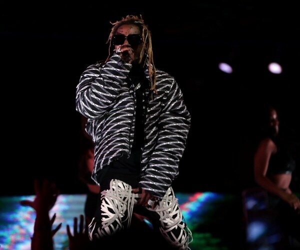 lil wayne raps on stage and grabs his crotch