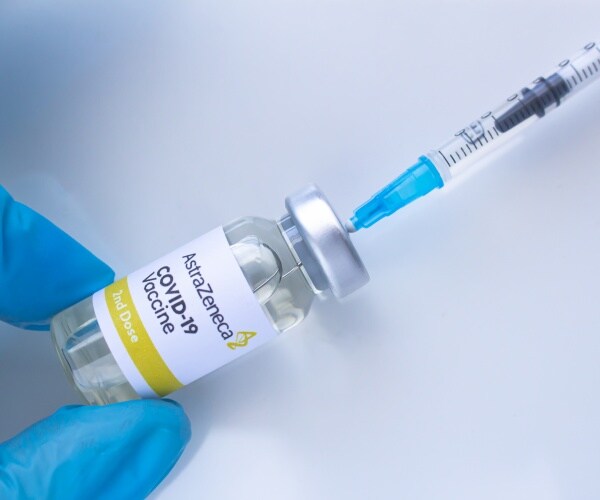 vial labeled 'AstraZeneca COVID-19 Vaccine' with a syringe in it