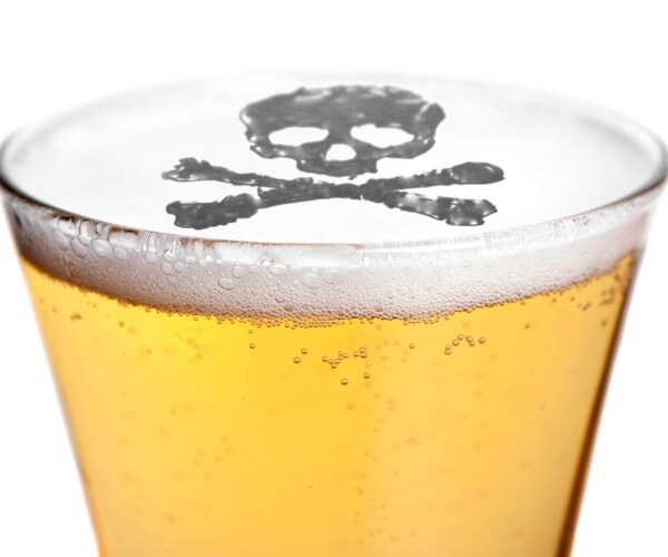 close-up of top of beer in glass with skull and crossbones in the foam of beer