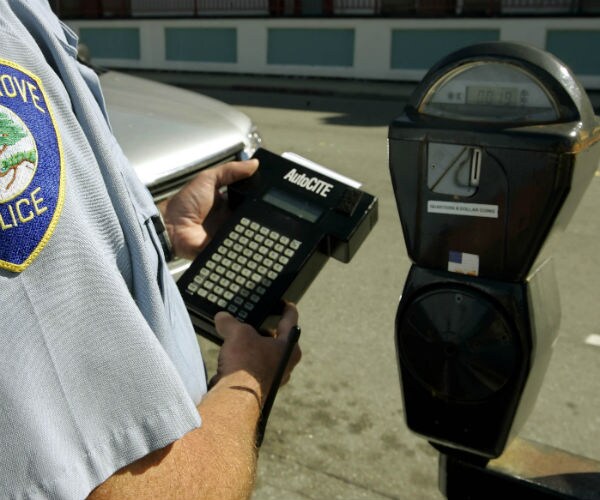 police officer checking parking meter