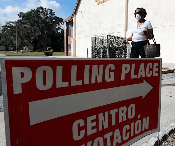 A voter wearing a face mask leaves a polling station for the Florida presidential primary Tuesday