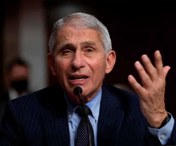 anthony fauci raises hand as he speaks