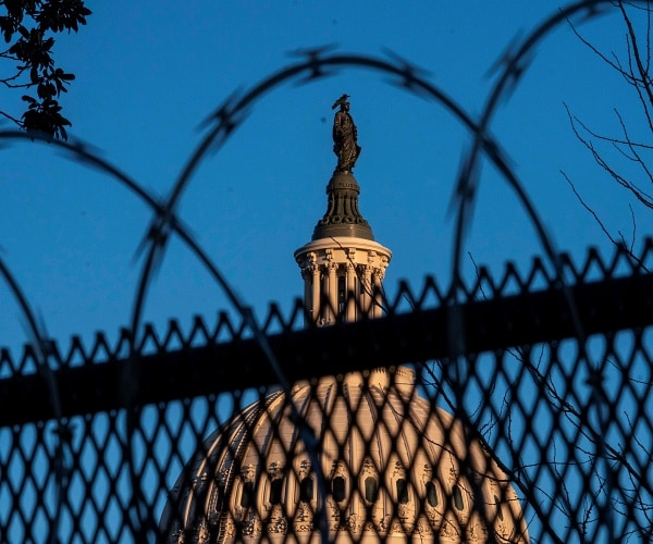 capitol building behind barbed wire fencing