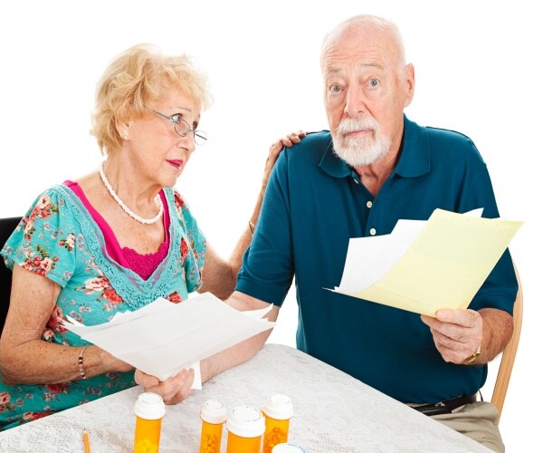 a man and a woman going over insurance bill with exasperation