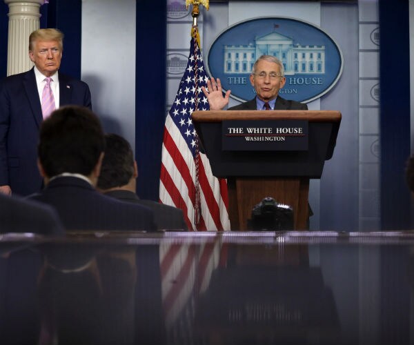 dr fauci is shown with donald trump and vice president mike pence