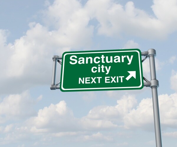 sanctuary city concept as a highway sign directing to welcoming immigrants with no legal status