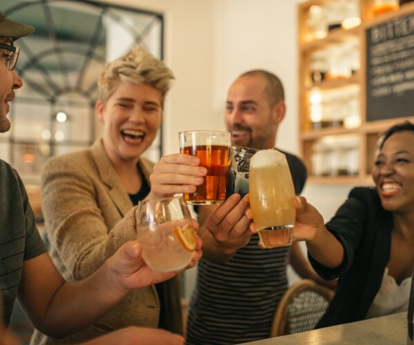 friends in a bar cheering with their drinks