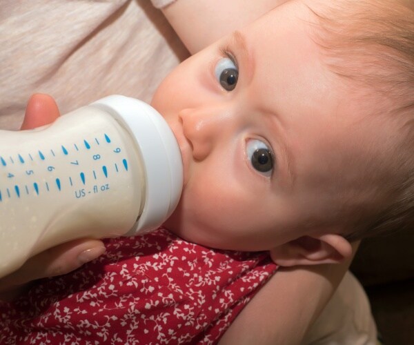 baby drinking formula from bottle