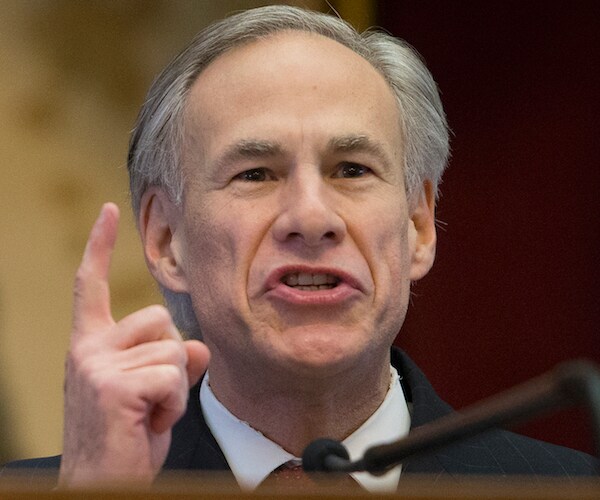 greg abbott points and speaks during a hearing