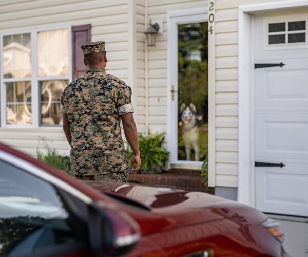 veteran in fatigues coming home to dog waiting for him at front door