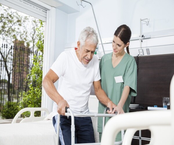 a nursing home staff helping a male resident