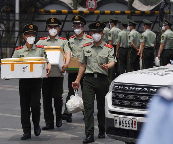 chinese police officers at the entrance of the xinfadi market in beijing