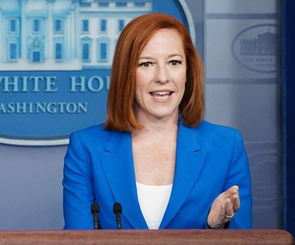 jen psaki speaks from behind podium