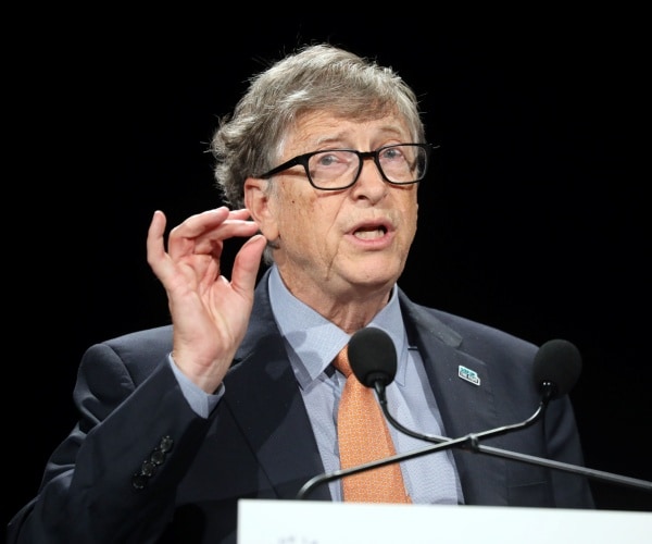 bill gates in a suit, light blue shirt, and orange tie